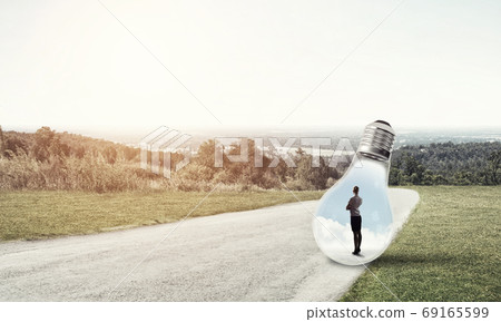 Businesswoman inside light bulb Businesswoman inside light bulb 69165599