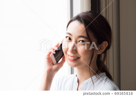 Young woman talking on a smartphone Young woman talking on a smartphone 69165818