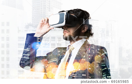 Handsome businessman in bokeh lights experiencing impressive virtual reality technology 69165985