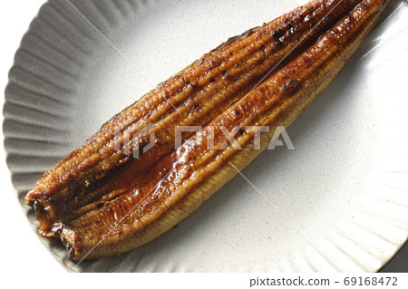 整個鰻魚的川崎在從白色背景採取的一塊圓的板材上（概述） 69168472