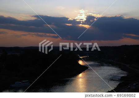 View of the Neman river and the city during sunset on a summer day. View of the Neman river and the city during sunset on a summer day. 69169802