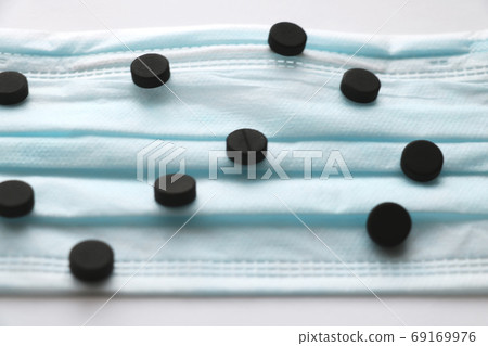 Pills on a medical mask. Coronavirus, epidemic, pandemic. Place for text. Selective focus. 69169976