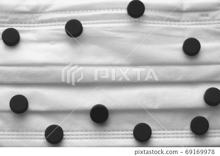 Pills on a medical mask. Coronavirus, epidemic, pandemic. Place for text. Selective focus. 69169978