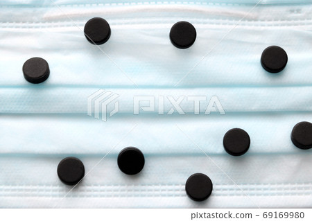 Pills on a medical mask. Coronavirus, epidemic, pandemic. Place for text. Selective focus. 69169980