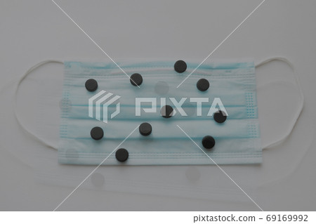 Pills on a medical mask. Coronavirus, epidemic, pandemic. Place for text. Selective focus. 69169992