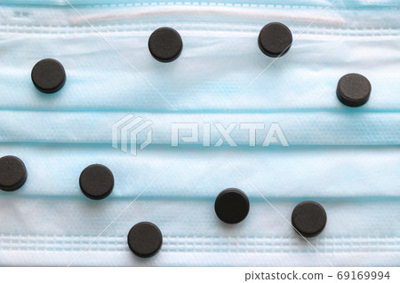 Pills on a medical mask. Coronavirus, epidemic, pandemic. Place for text. Selective focus. 69169994