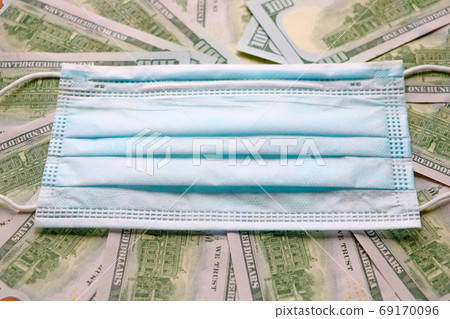 Medical mask on dollars as a symbol of increasing prices for protecting the respiratory tract from the virus. There is a place for copyspace. 69170096