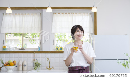 戴眼鏡的微笑的婦女在廚房裡 69170735