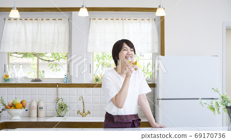 戴眼鏡的微笑的婦女在廚房裡 戴眼鏡的微笑的婦女在廚房裡 69170736