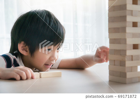 Cute Asian child playing wood blocks stack game Cute Asian child playing wood blocks stack game 69171872