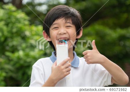 Cute Asian child  drinking a carton of milk  69171982