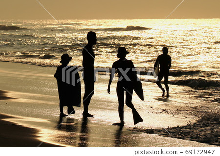 黎明時在海灘上的衝浪者父母和孩子 69172947