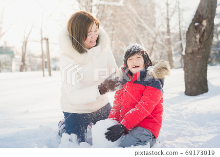 Asian mother and son enjoying snowy winter Asian mother and son enjoying snowy winter 69173019