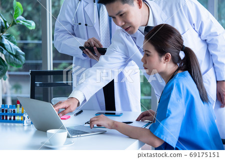 Doctor and medical assistants discussing about diagnosis result on laptop. 69175151