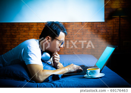 young asian man staring at laptop computer screen in bedroom at night. eye problems concept young asian man staring at laptop computer screen in bedroom at night. eye problems concept 69176463