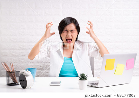 Angry woman screaming at office 69177802