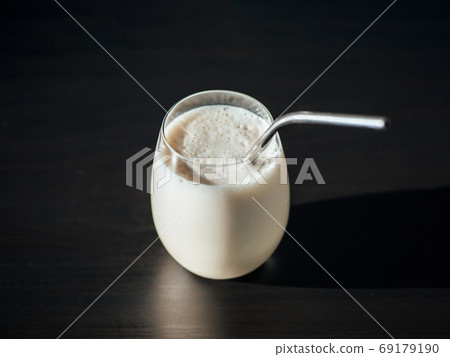 Protein milkshake in glass with metal straw Protein milkshake in glass with metal straw 69179190