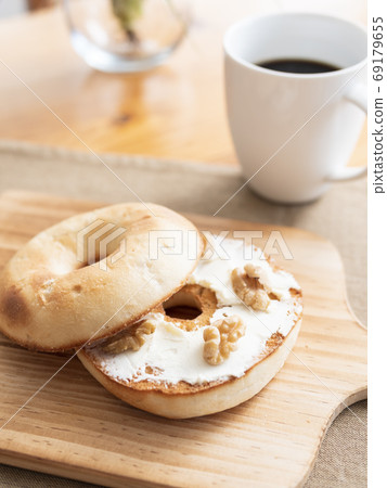 在烤百吉餅上塗奶油乾酪 在烤百吉餅上塗奶油乾酪 69179655