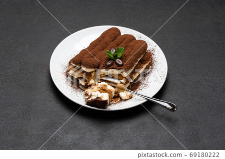 portion of Classic tiramisu dessert on ceramic plate on concrete background portion of Classic tiramisu dessert on ceramic plate on concrete background 69180222