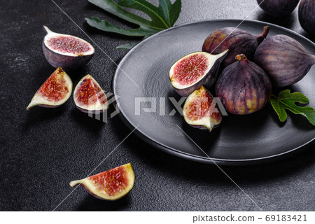 Fresh ripe figs on a dark concrete background. Harvesting figs Fresh ripe figs on a dark concrete background. Harvesting figs 69183421