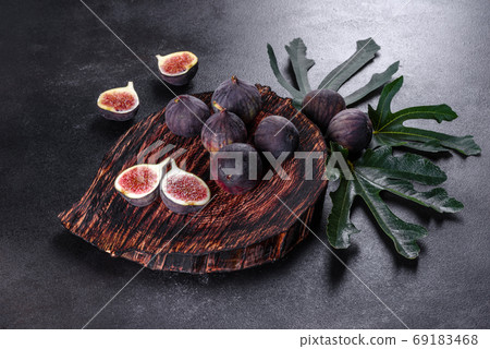 Fresh ripe figs on a dark concrete background. Harvesting figs Fresh ripe figs on a dark concrete background. Harvesting figs 69183468