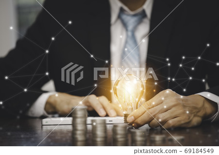 Businessman hand holding light bulb with line connect and Coins stack  69184549