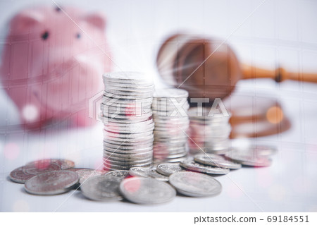 Coins stack and pink piggy and Old wood Judge hammer with line graph  69184551