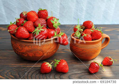 awberries in pottery on a wooden table. Side view awberries in pottery on a wooden table. Side view 69184730