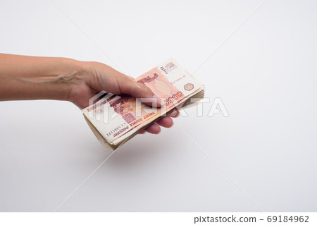 Hand holds out a stack of five thousandth bills 69184962