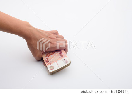 Hand takes from a white background a pack of five thousandth bills 69184964