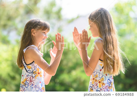 Children play ladlets walking in a city park, 69184988
