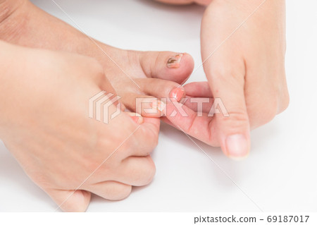 Women's hands putting nail stickers 69187017