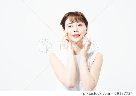 微笑用她的在她的面頰（白色背景）的手的一個少婦 69187724