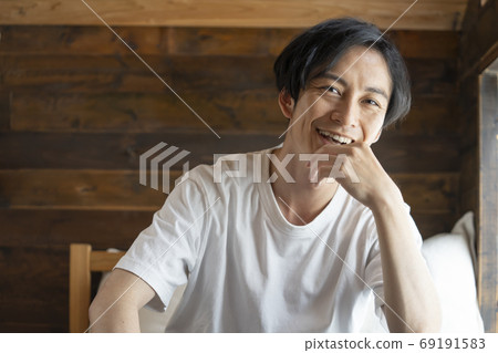 Portrait of a young man looking at the camera Portrait of a young man looking at the camera 69191583