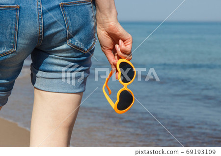 Hand of woman with sunglasses in shape of heart. Summer time Hand of woman with sunglasses in shape of heart. Summer time 69193109