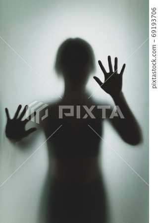 Ghost concept shadow of a woman behind the matte glass blurry ha Ghost concept shadow of a woman behind the matte glass blurry ha 69193706