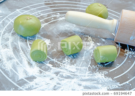 Preparing to bake asian cookies. Rolling pin, Dough on silicone baking mat 69194647