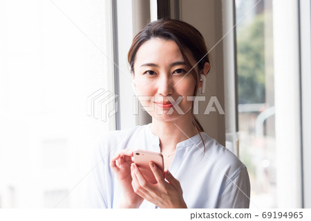 A woman making a videophone call on a smartphone A woman making a videophone call on a smartphone 69194965