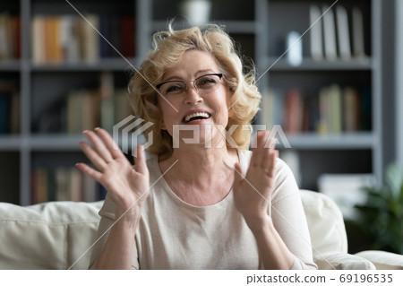 Head shot portrait overjoyed mature woman making video call Head shot portrait overjoyed mature woman making video call 69196535