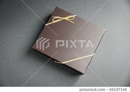 Black gift box with a golden ribbon on black background Black gift box with a golden ribbon on black background 69197346