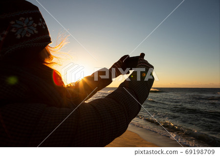 Woman traveler photographs the sea Woman traveler photographs the sea 69198709