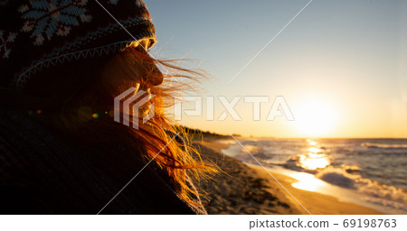 Woman traveler looks at the sea at sunrise. Woman traveler looks at the sea at sunrise. 69198763