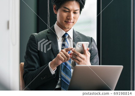 Businessman using a smartphone on the go 69198814