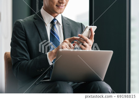 Businessman using a smartphone on the go Businessman using a smartphone on the go 69198815