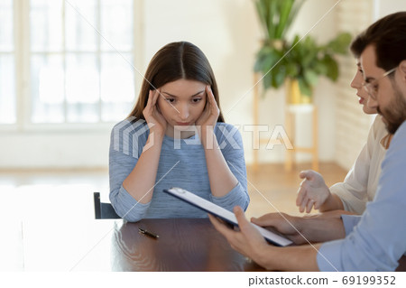 Stressed businesswoman realtor touching temples, dissatisfied clients complaining Stressed businesswoman realtor touching temples, dissatisfied clients complaining 69199352