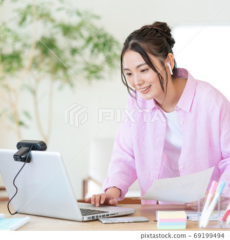 Telework Smiling young woman working in living room square Telework Smiling young woman working in living room square 69199494