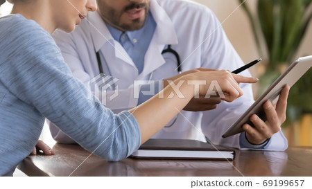 Close up doctor therapist consulting female patient, using tablet 69199657