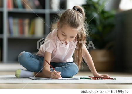Pretty little girl playing on warm floor, drawing with pencils 69199662