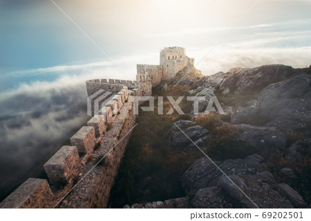 Medieval fortress, wall and tower landscape with cloudy sky. Medieval fortress, wall and tower landscape with cloudy sky. 69202501