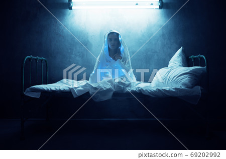 Mad woman in garlands sitting in bed, insomnia 69202992